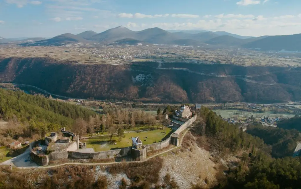 Aerial view of the Ostrozac Castle in Bosnia and Herzegovina; scenic mountainscape in the background