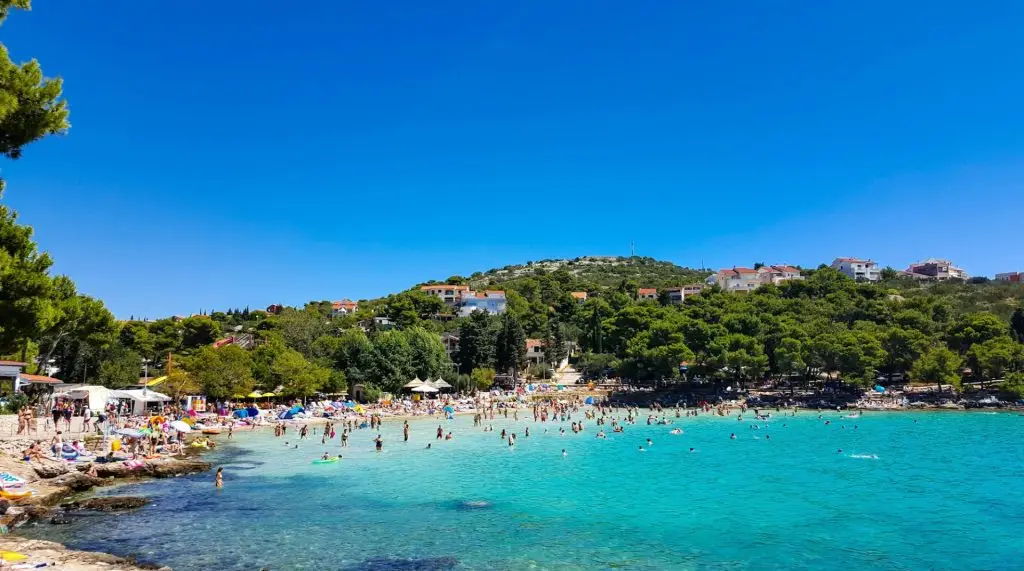 Crowded beach on island during summer vacation in Croatia.