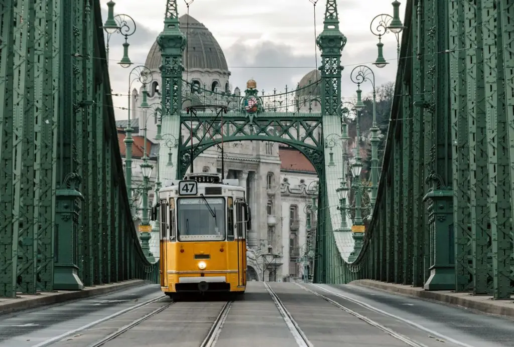 Yellow tram on Liberty bridge in city of Budapest, Hungary.