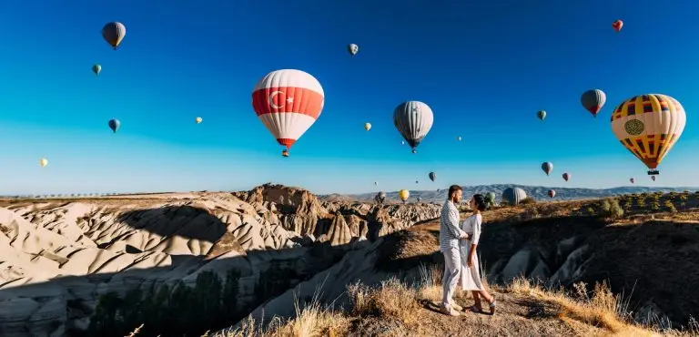 A beautiful couple on the background of balloons in Cappadocia. Travel to Turkey. Best Places to Visit in Turkey