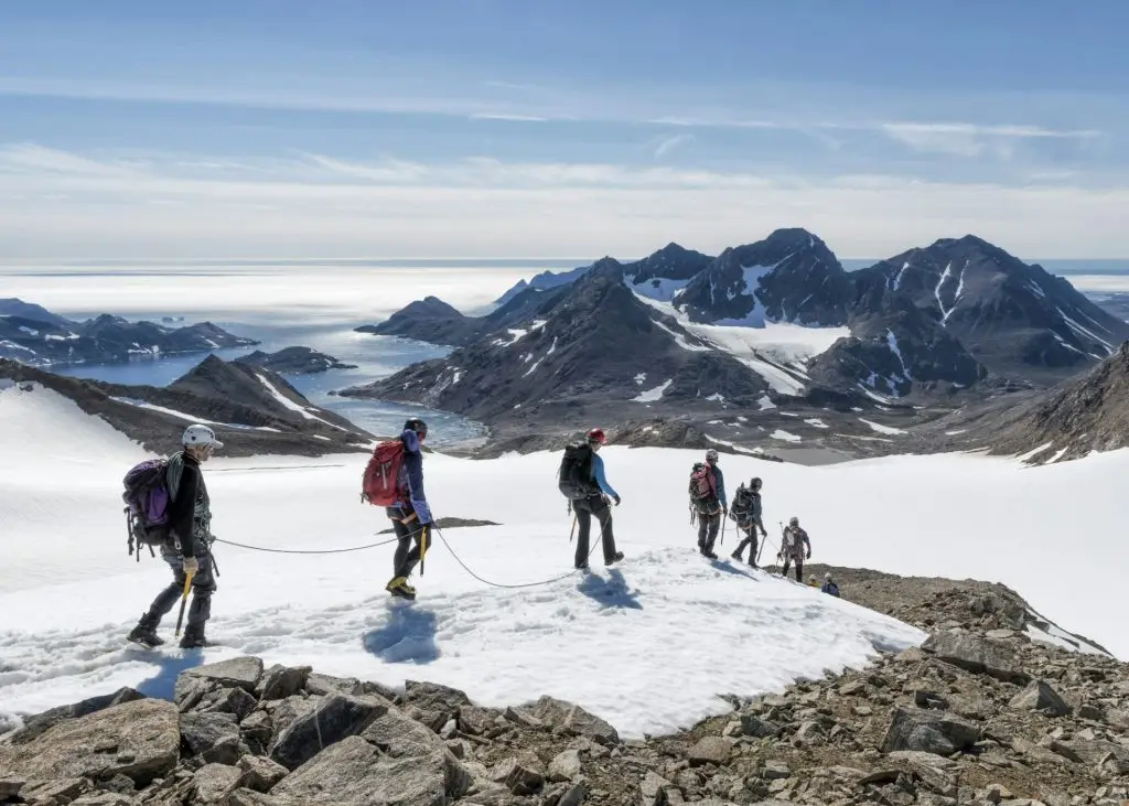 Greenland, Sermersooq, Kulusuk, Schweizerland Alps, group of people walking in snow
