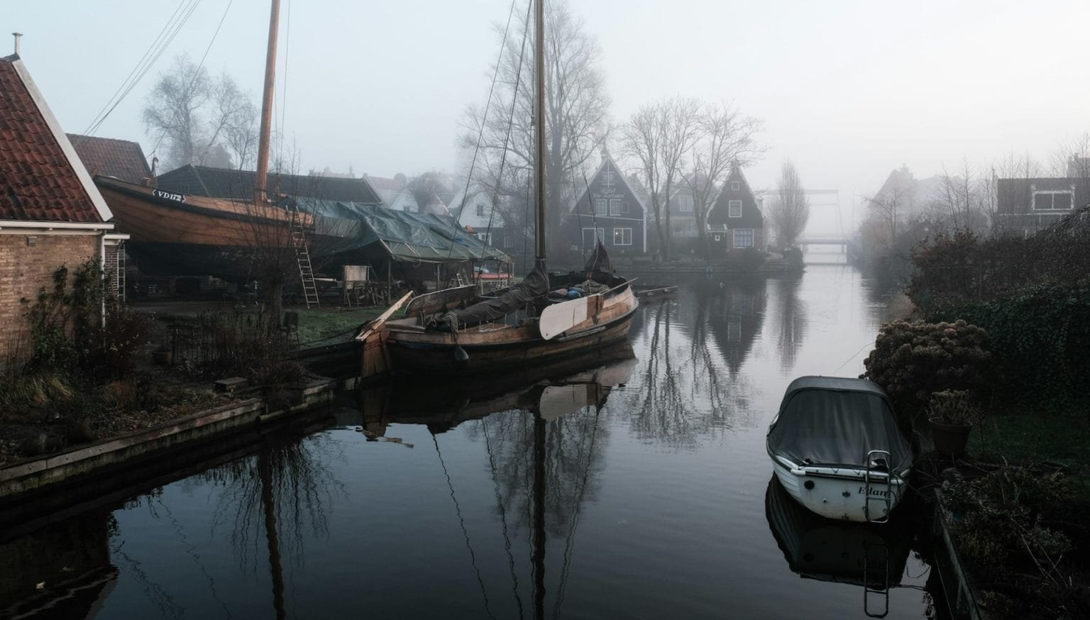 Historical shipyard with a historical sailing ship on a foggy morning in Edam