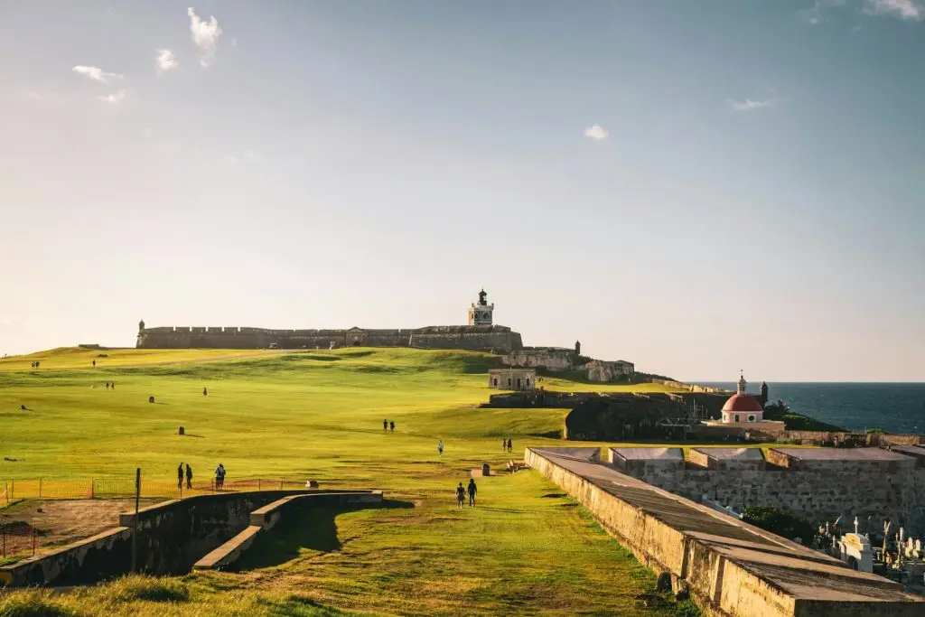 Landscape view of El Morro with visitors in sunlight, San Juan, Puerto Rico