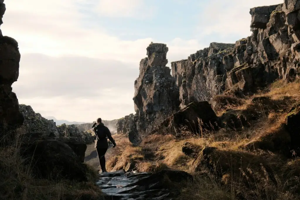 Rear view of a female tourist walking at the beautiful Thingvellir National Park in Iceland