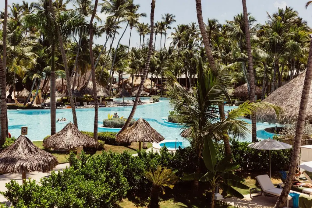 resort pool, leaf umbrellas, and the beach in Punta Cana, Dominican Republic