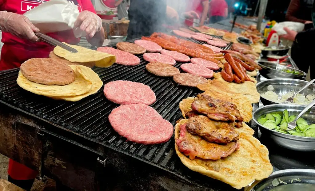 Serbian cuisine grilled burger patties and tortillas sausages chicken and salads on bbq grill