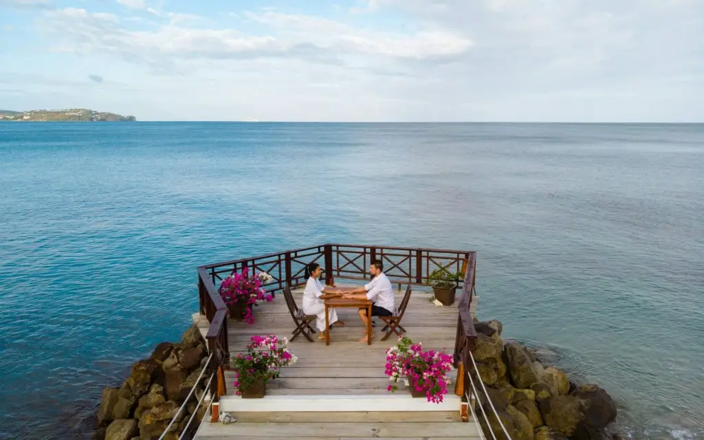 young couple relaxing at a wooden pier in ocean, Saint Lucia, luxury holiday Saint Lucia Caribbean