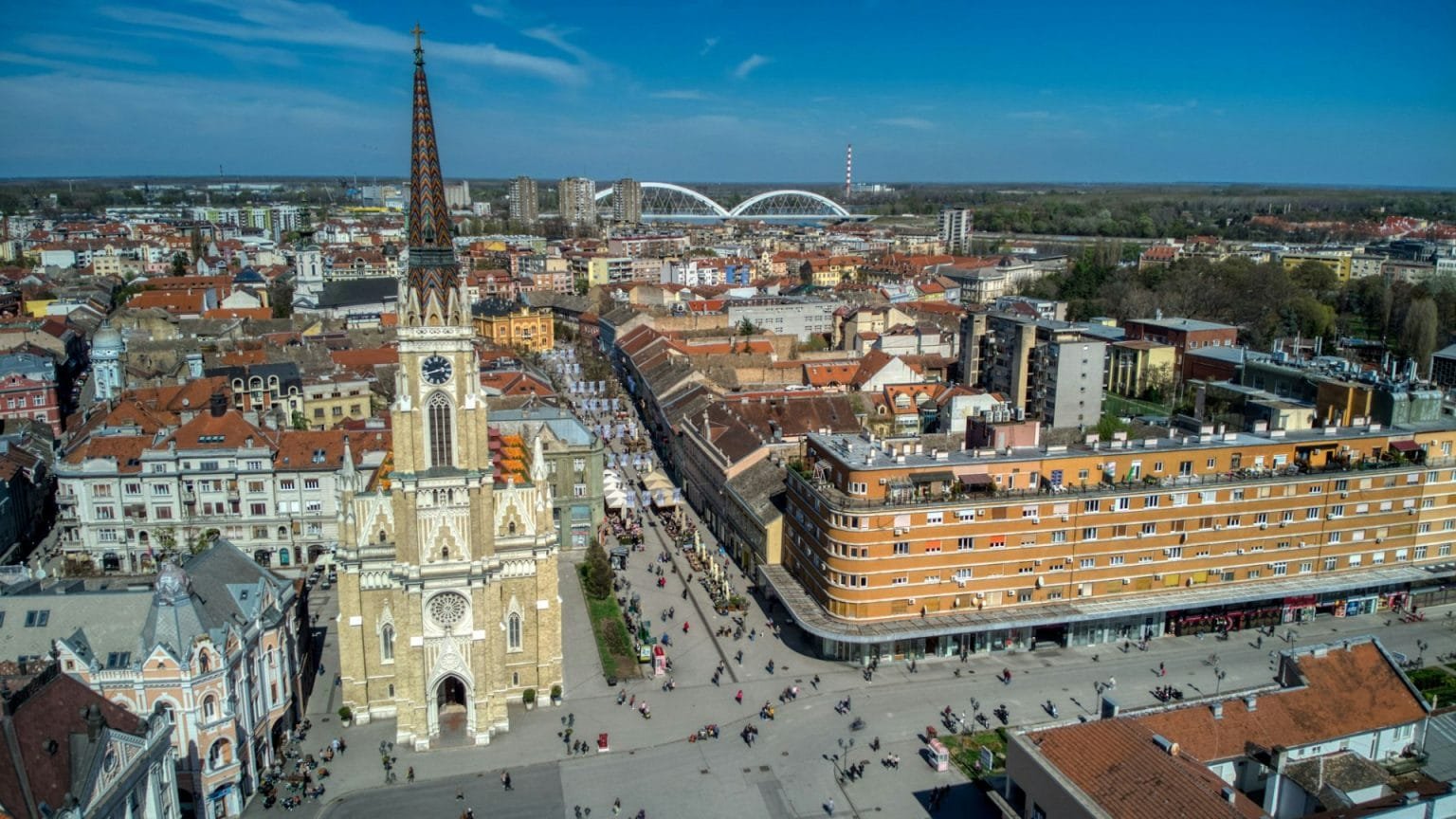 Aerial view of Novi Sad city with a catholic cathedral and dense buildings under the blue sky