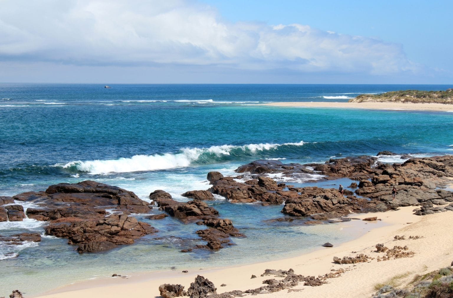 Margaret River Western Australia. Showing one of the popular surfing beaches of Margaret River where the river enters the Indian Ocean on the right and at low tide the rocks are exposed.