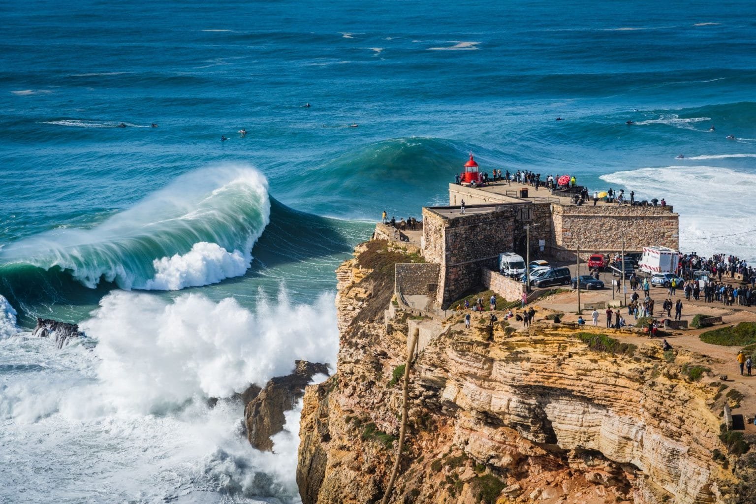 Giant waves crashing near the Fort of Sao Miguel Arcanjo Lighthouse in Nazare, Portugal. Nazare is famously known to surfers for having the biggest waves in the world.