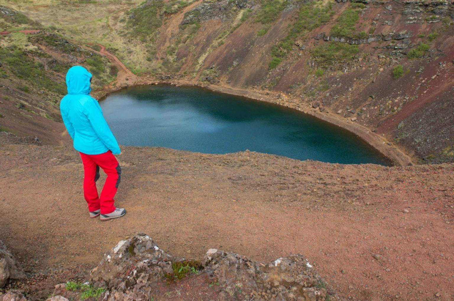 Tourist admiring the Kerid crater lake in the Golden Circle, Southern Iceland