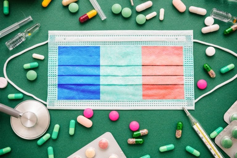 Covid19 virus in France, protective surgical french flag mask and medicine background.