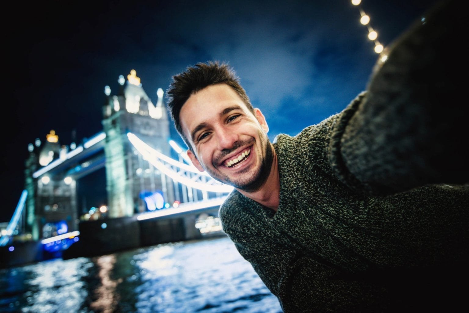 Happy young man taking selfie in Tower Bridge, London
