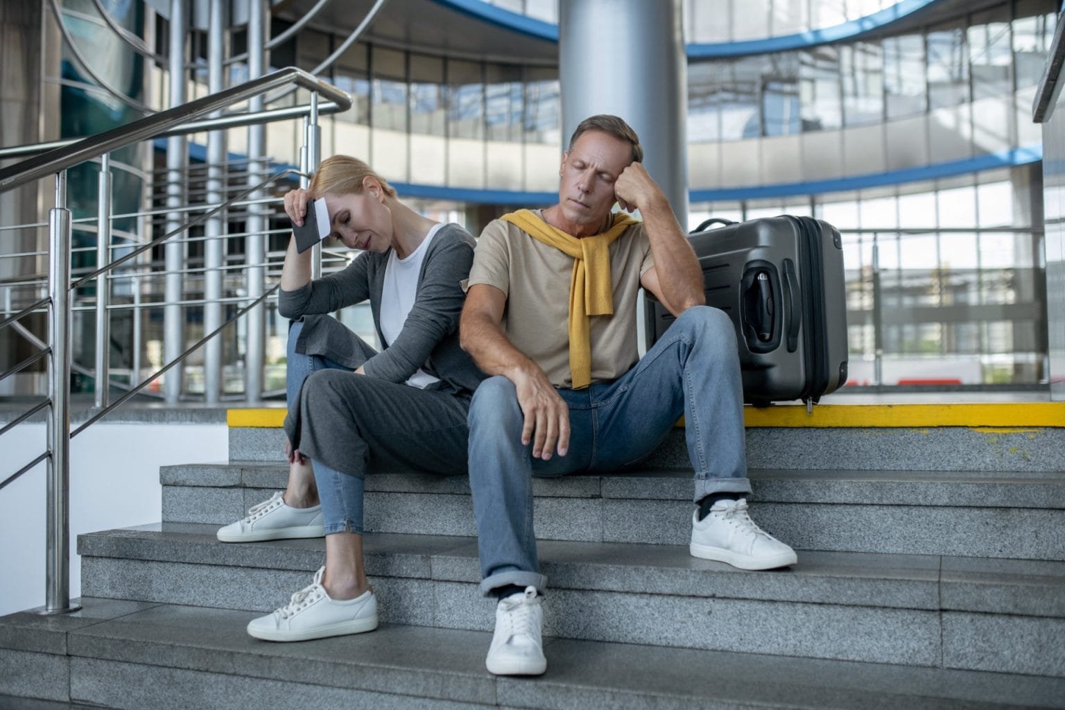 Two exhausted tourists dozing at the airport terminal