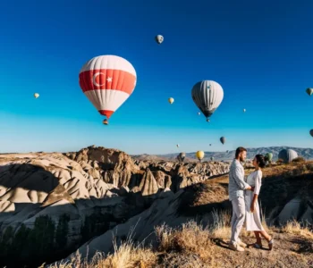 A beautiful couple on the background of balloons in Cappadocia. Travel to Turkey. Best Places to Visit in Turkey