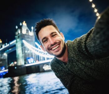 Happy young man taking selfie in Tower Bridge, London