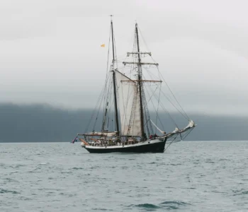 HUSAVIK, ICELAND - 20 JULY, 2016: yacht floating on waves near icelandic coast, husavik, iceland