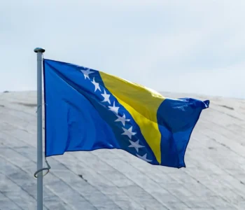 The national flag of Serbia waving in the blue sky