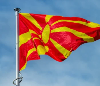 The national flag of Serbia waving in the blue sky