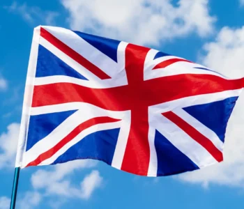 United Kingdom Flag waving on wind in blue sky