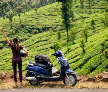 woman traveler resting on motobike in tea plantations in india kerala munnar