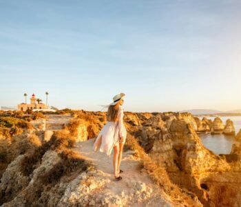 Woman traveling on the rocky coastline in Lagos, Portugal, Places to Visit in Portugal